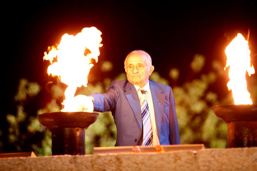 Holocaust survivor Baruch Kopold lights one of the six torches at the ceremony