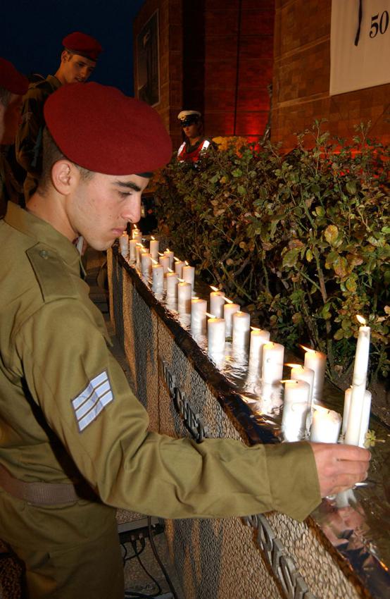 חייל מדליק נרות לפני תחילת הטקס