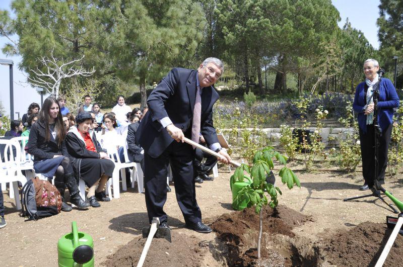 Avner Shalev, Chairman of Yad Vashem,  plants the sapling.