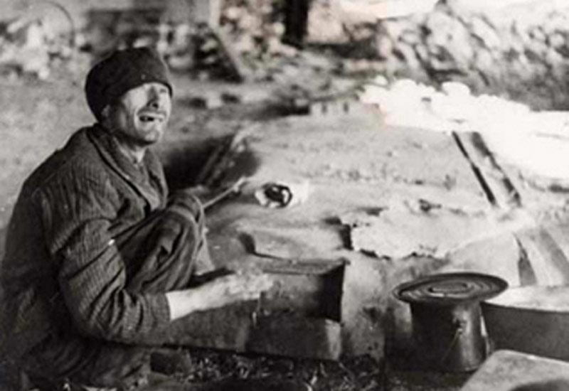 April 1945, A Survivor Next to a Pot of Potation, Nordhausen, Germany