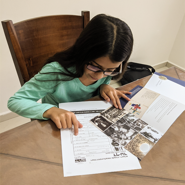 מאיה מירושלים עם חוברת הלימוד ודפי העד שקיבלה במסגרת תכנית שליחי זיכרון