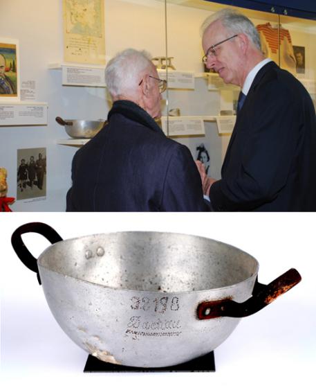 Shlomo Resnik (left) showing Dr. Benedikt Haller, the deputy German ambassador to Israel, the metal bowl that he received in Dachau
