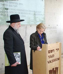 Secretary Clinton signs the Yad Vashem Guest Book at the Exit to the Children's Memorial at the end of her visit today. Rabbi Israel Meir Lau, Chairman of the Yad Vashem Council is at her side