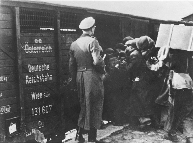 Евреев грузят в товарные вагоны во время депортации в Белжец