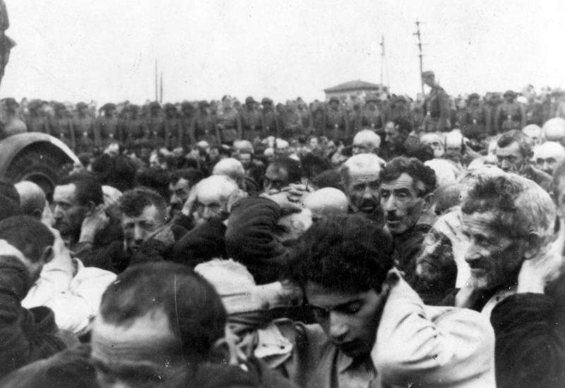 גברים יהודים תחת שמירת חיילים גרמנים, ז'יטומיר, אוקראינה, 07/08/1941.