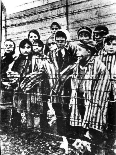 Польща, Аушвіц. Діти біля колючого дроту після звільнення табору. Лютий 1945 року.