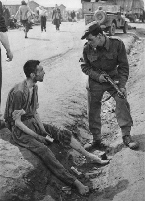 Soldado britânico falando com um prisioneiro do campo após a libertação; Bergen Belsen, Alemanha