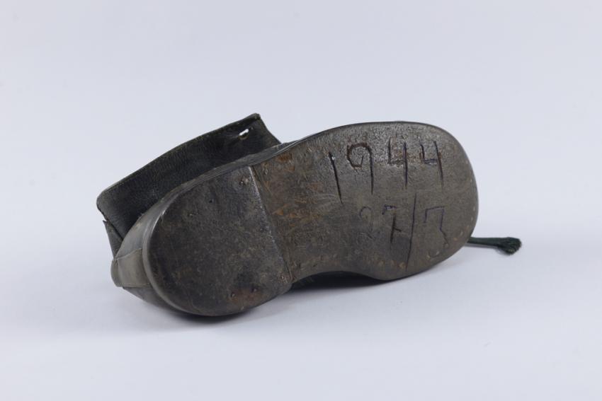 The baby shoe of Hinda Cohen, with the date of her deportation to the death camp carved into the sole by her father