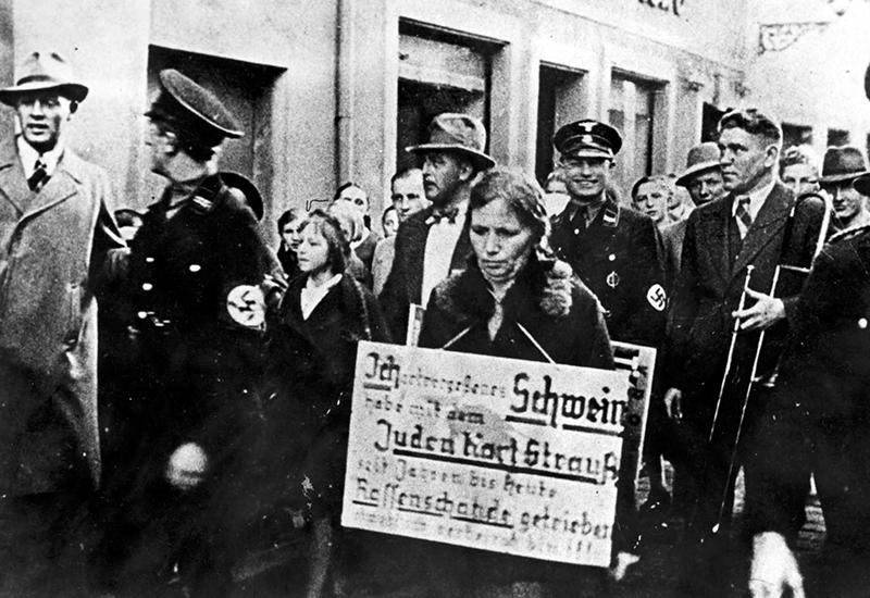 אנשי ס"ס משפילים אשה ברחוב, קולמבך, גרמניה, 1938.