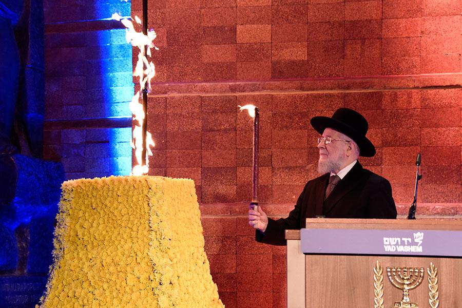 יושב ראש מועצת יד ושם, הרב ישראל מאיר לאו, מדליק את אבוקת הזיכרון במהלך העצרת