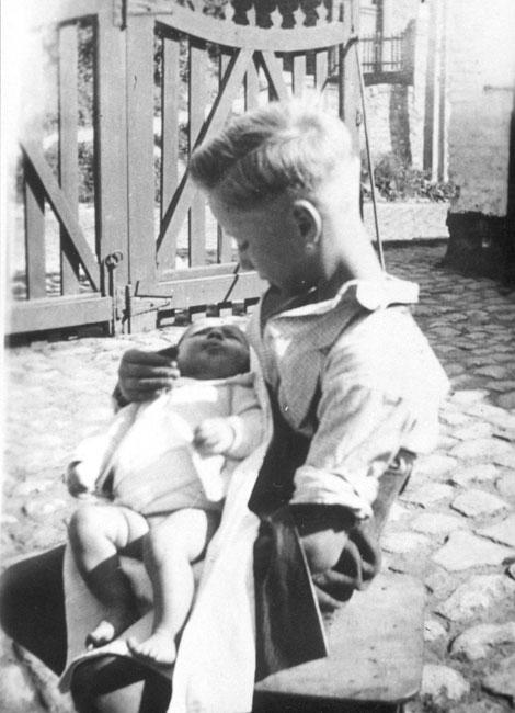 הניצול מחזיק את בתה התינוקת של המצילה, 1947