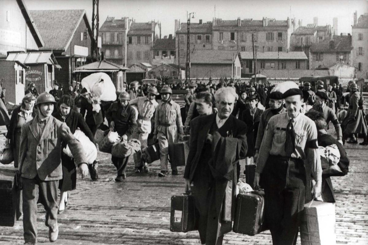 Juifs et non-Juifs raflés dans le Vieux-Port de Marseille conduits vers la gare d’Arenc encadrés par des policiers français et allemands, matin du 24 janvier 1943.