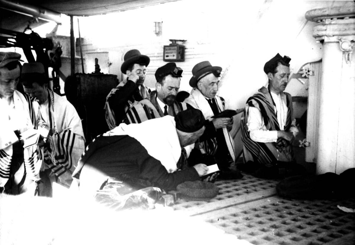Hombres rezando en la cubierta del «Patria» como parte de la Operación «de los 700», septiembre de 1936