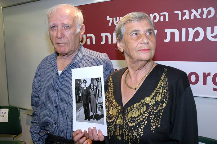 סיימון גלסברג והילדה שליק מחזיקים תמונה של הוריהם