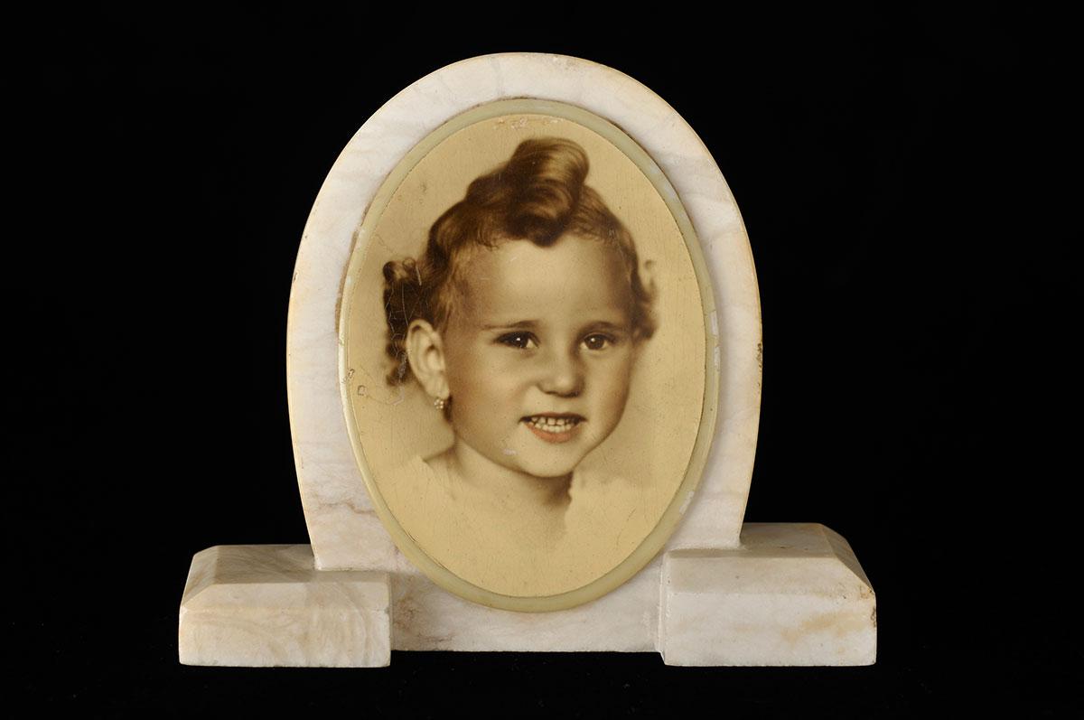 Photo of Yehudit Friedman that her mother Zsuzsanna  had printed on a marble slab after the war