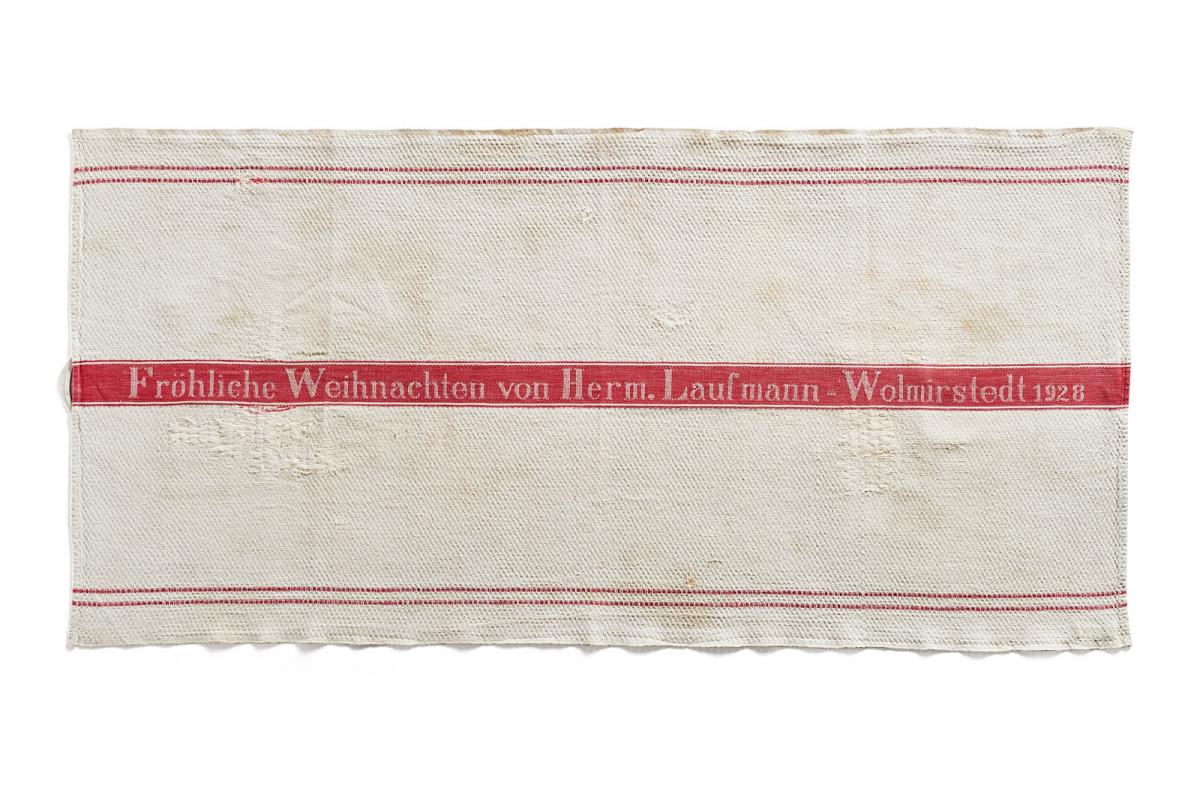 Ein Handtuch, das 1928 im Geschäft der Familie Laufmann in Wolmirstedt mit einem fröhlichen Weihnachtsgruß hergestellt wurde