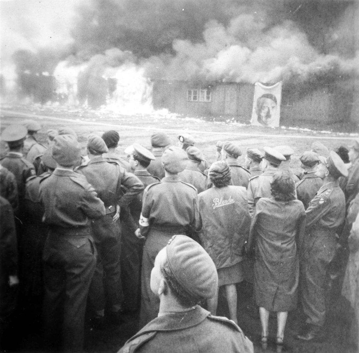 Survivors and liberators watching the camp burning, Bergen-Belsen, Germany