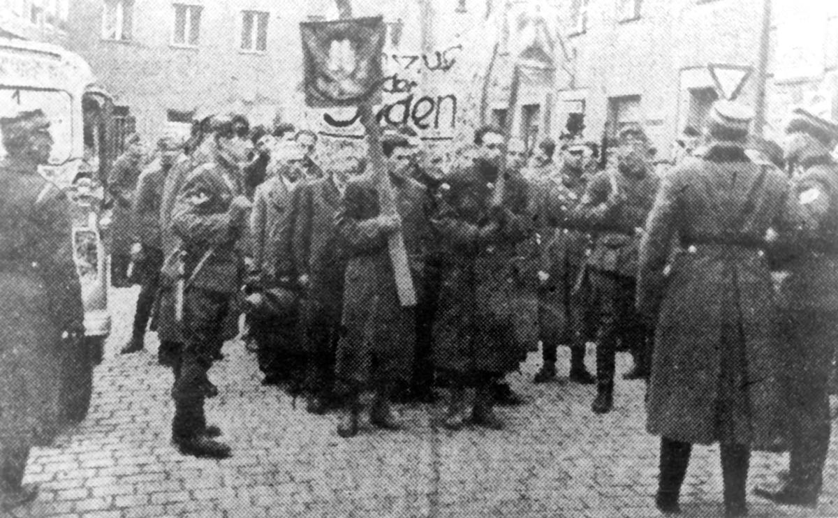 Jewish men under the watch of an SA guard as they are taken under arrest to the Gestapo building in Regensburg during the November Pogrom (&quot;Kristallnacht&quot;) in 1938. 