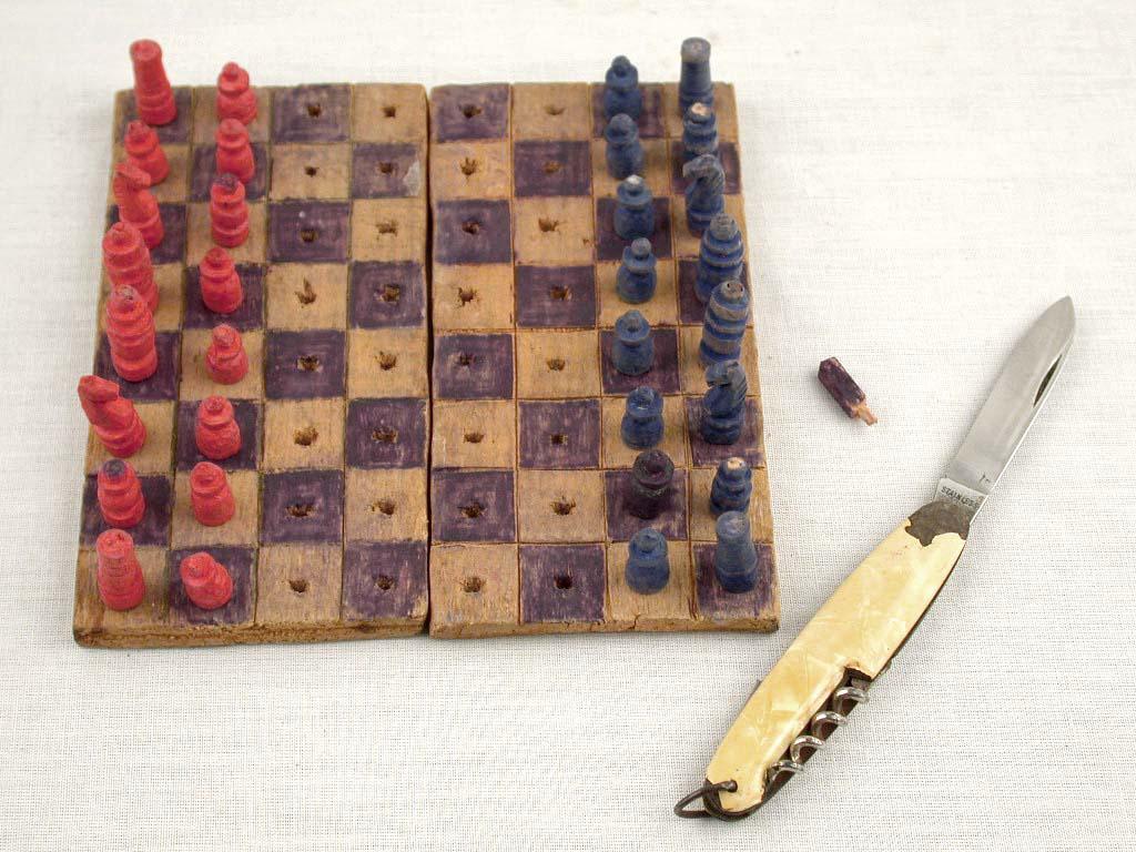 Piezas de ajedrez talladas por Elhanan Ejbuszyc en Auschwitz-Birkenau y el cortaplumas utilizado para tallarlas