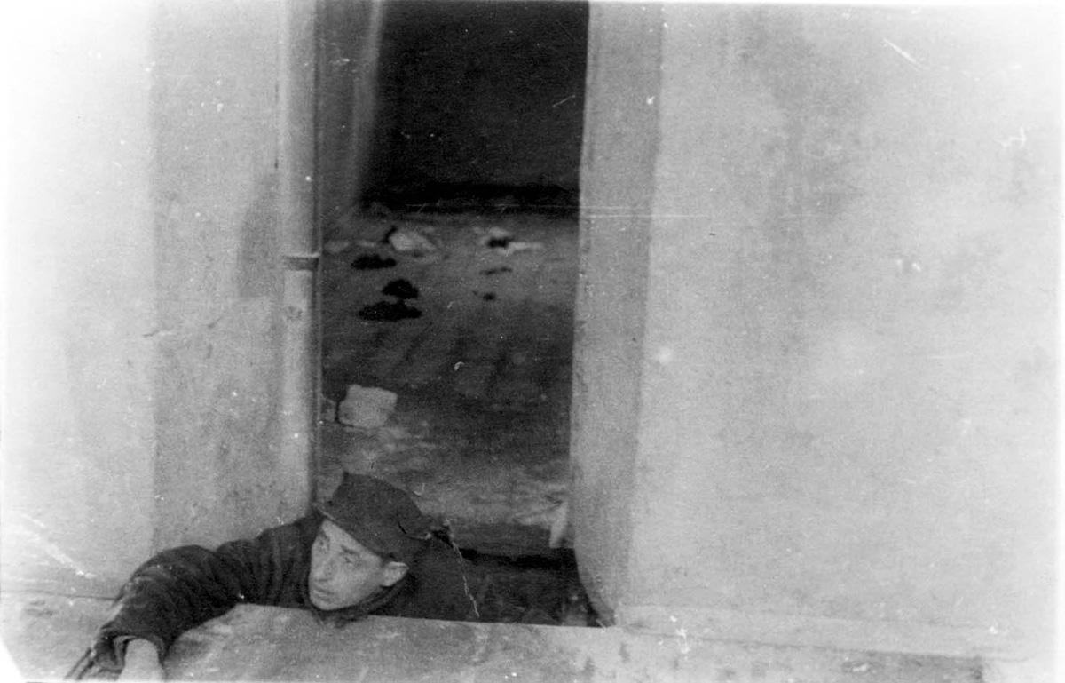 Jew climbing out of a &quot;malina&quot; (hiding place) at 6 Strashun Street in Vilna. The underground fighters learned to shoot in this hiding place.