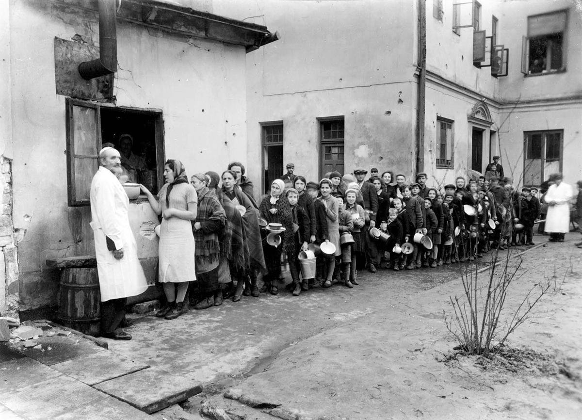 תור ממתינים לחלוקת מרק ליד בית המחסה לפליטים ברחוב דזיילנה 7 במהלך פסח 1940 בוורשה. במקום זה שוכנו בעיקר פליטים מהעיירות קאליש וליפנו. 