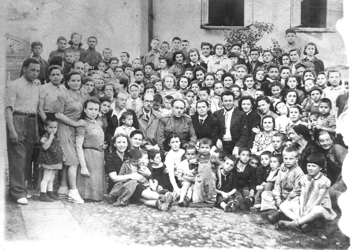 בית היתומים היהודי בווילנה, 1944. בשורה הקדמית, רביעית משמאל, בשמלה אפורה על הברכיים, זלטה (זהבה) בורגין. במרכז, במדים, פרופ' רבלסקי – ה&quot;אבא&quot; של בית היתומים