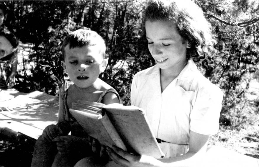 Ein älteres Mädchen liest einem Jungen vor