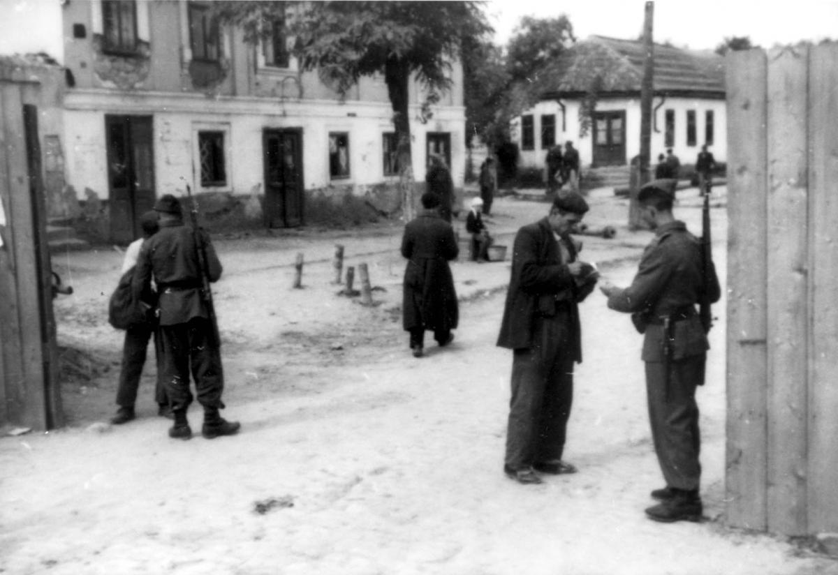 חייל רומני בודק מסמכי מעבר ליהודי, בשער רובע יהודי, בסרביה, רומניה