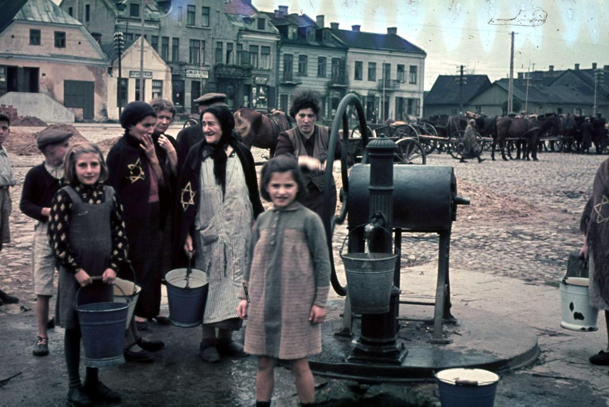 Jewish women and children by a water pump in a town square, Gostynin, Poland, 1941