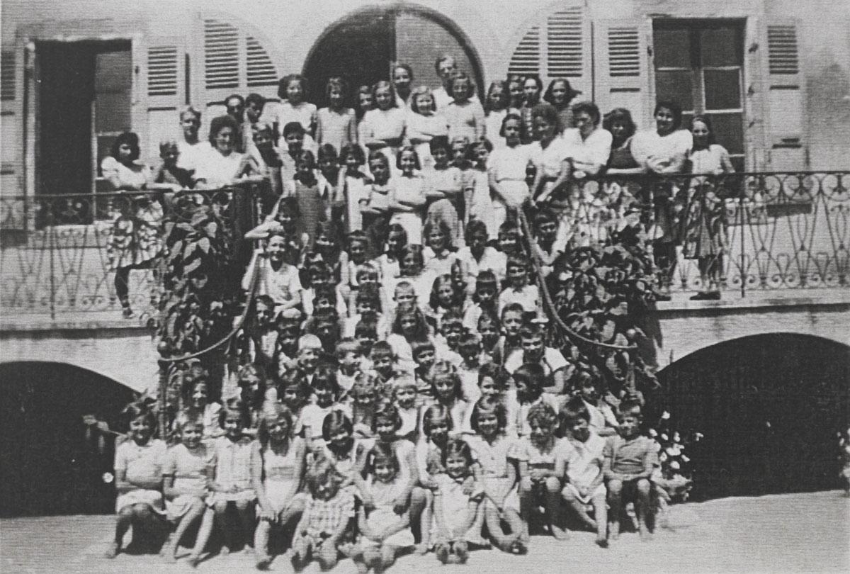Photo de tous les enfants et du personnel (rangs du haut), à la maison d'enfants, sur les mêmes marches que la photo précédente. Pringy, 1943
