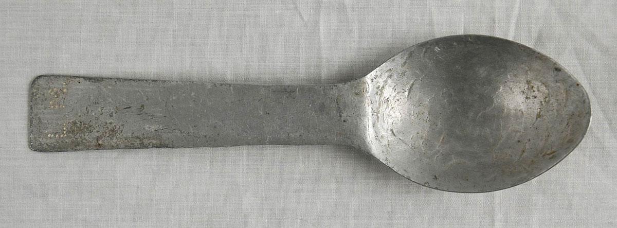 Cuchara afilada como cuchillo, utilizada por Arieh Mühlrad en el campo de concentración de Gusen. En el mango de la cuchara están inscritas las iniciales de su nombre: L M (Leon Mühlrad)