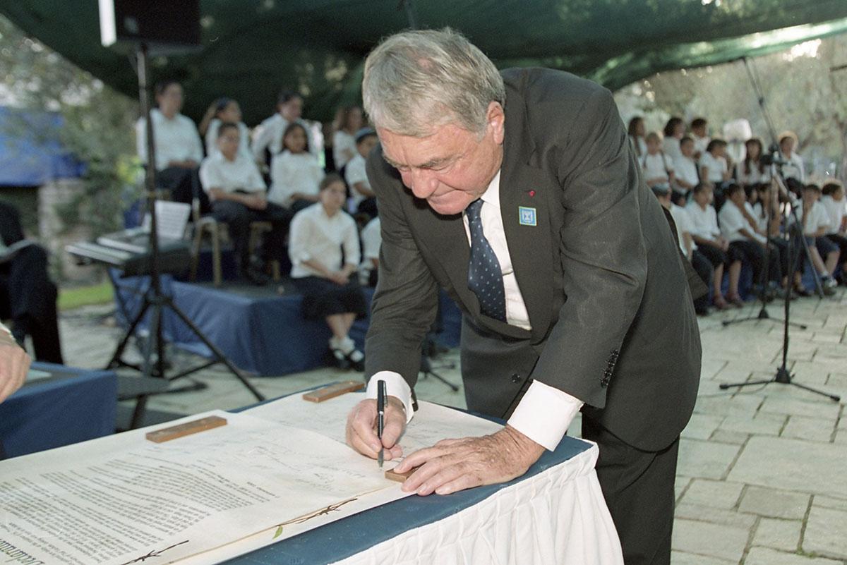 Claude Lanzmann signing the Yad Vashem &quot;Declaration of Remembrance&quot; at the ceremony marking 50 years since the establishment of Yad Vashem in 2003