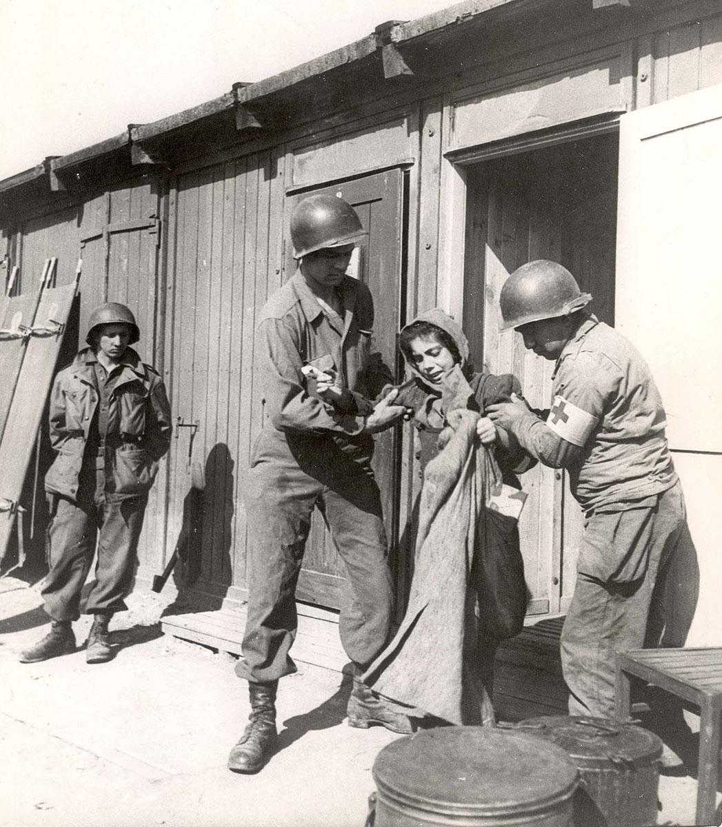 US soldiers help a survivor, Penig concentration camp, Germany, April 1945