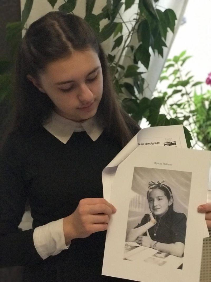 Avital Chuhareva holding a portrait of the Holocaust victim Yad Vashem twinned her with