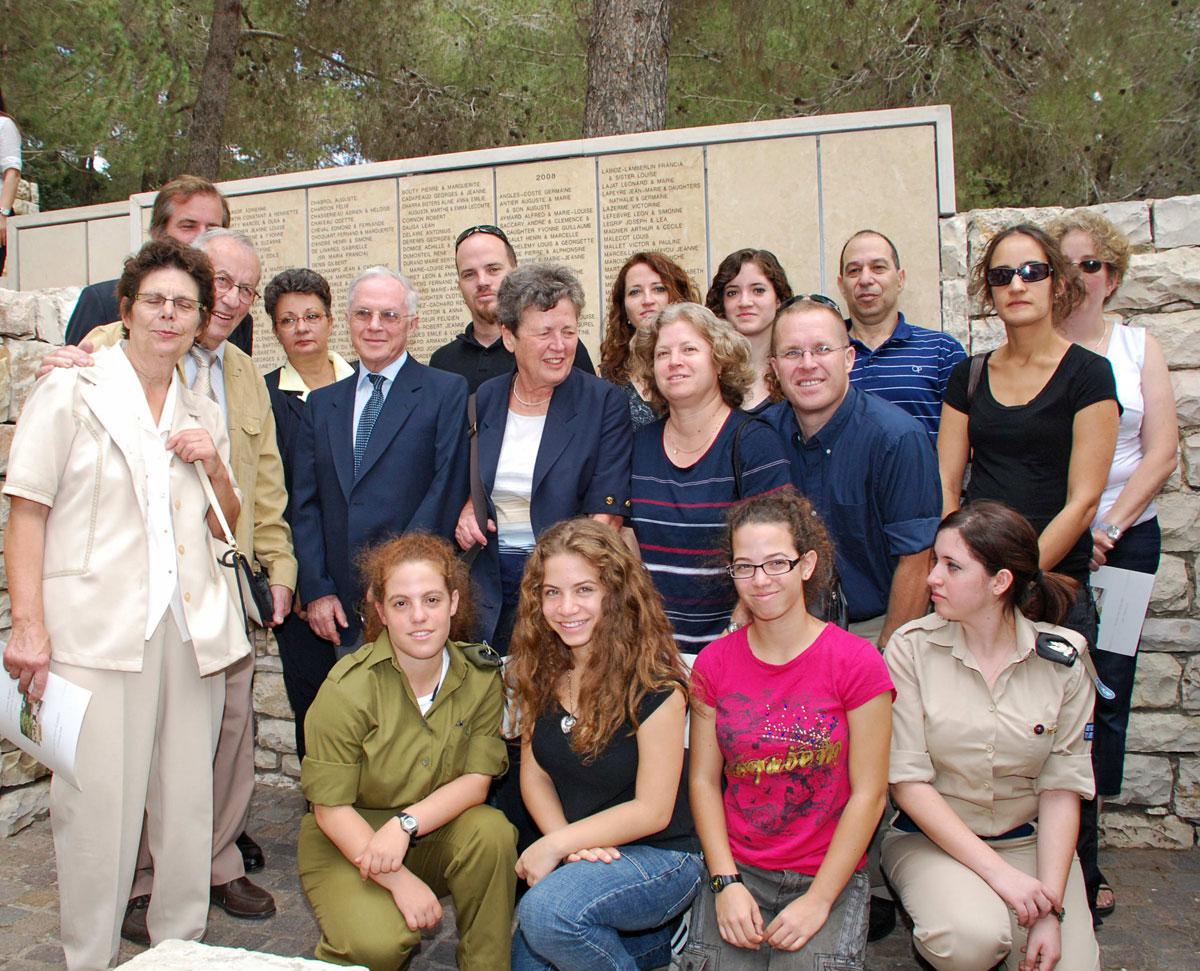 The family of survivor Ehud Loeb with the grandchildren of his rescuer, Louise Roger at the wall of honor in Garden of the Righteous