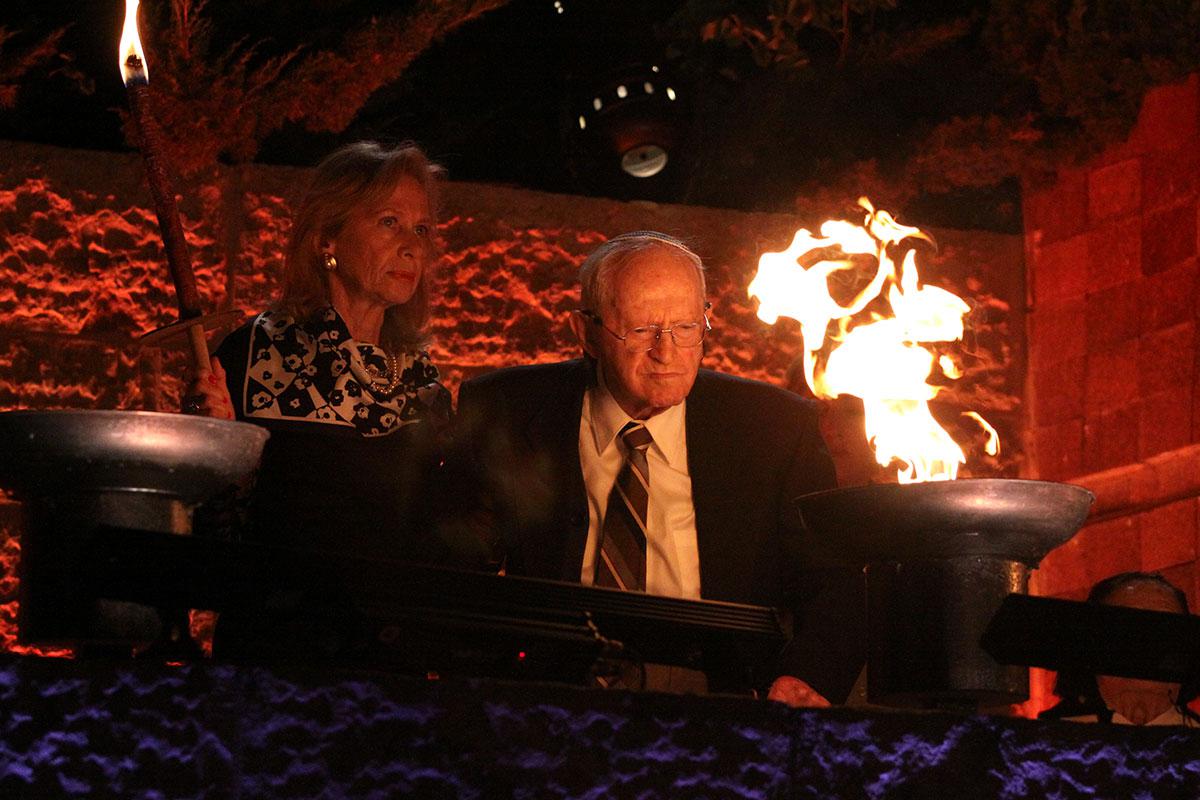 Holocaust survivor Robert Tomashof lights one of the six torches at the ceremony