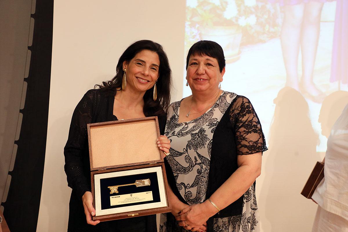 Leah Pisar-Haas reçoit les clés symboliques de Yad Vashem des mains de Miry Gross, directrice des Relations avec les pays francophones