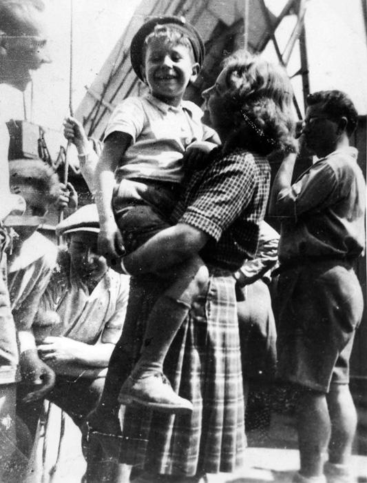 Eight-year-old &quot;Lolek,&quot; Israel Meir Lau (later Chief Rabbi of Israel and Chairman of the Yad Vashem Council) on deck at Marseille in the arms of Simone Chaumet, who came to bid farewell to the &quot;Buchenwald boys&quot; she had taken care of in Écouis