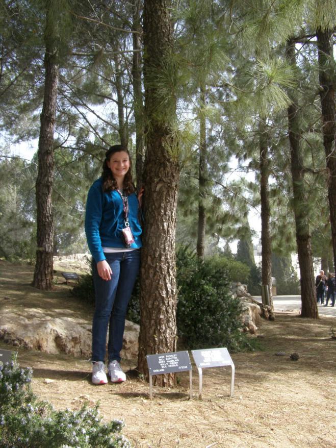 Dani Milner, granddaughter of Holocaust survivor  Sarah Hanna Rigler, beside the tree her grandmother planted