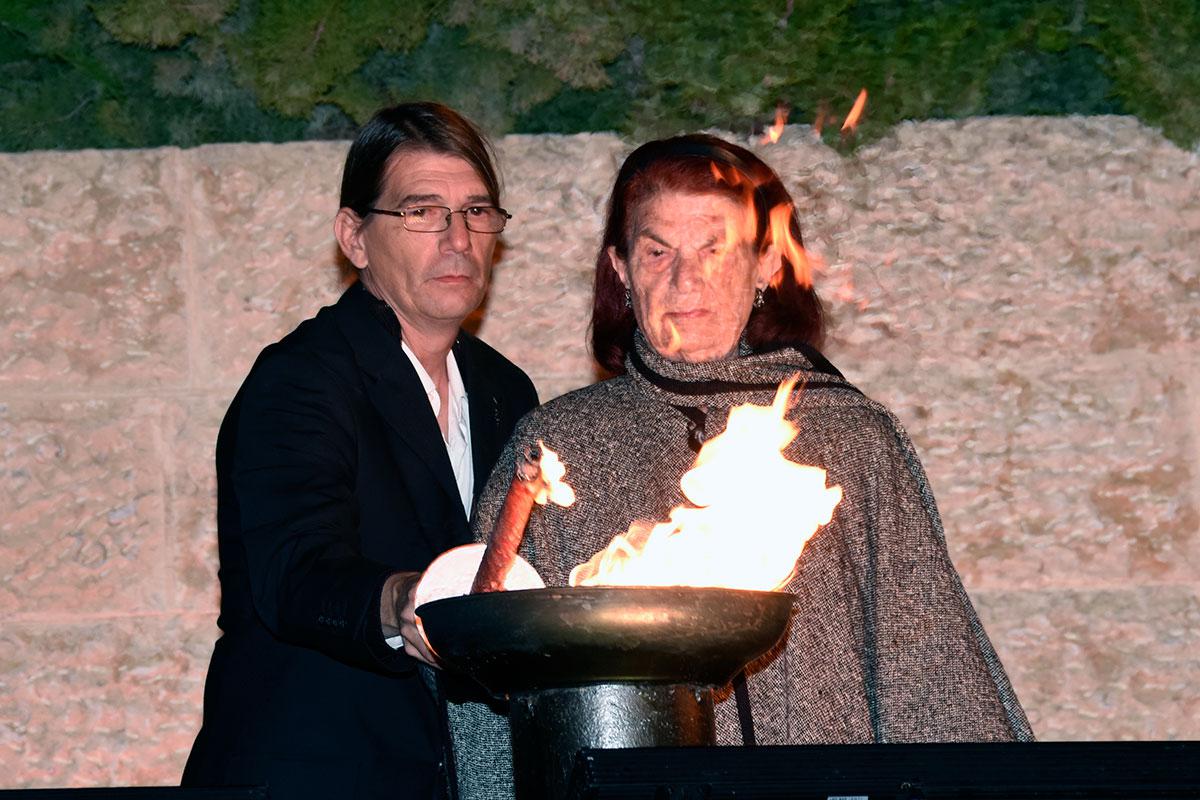 Holocaust survivor Jeannine Sebbane-Bouhanna lights one of the six torches at the ceremony