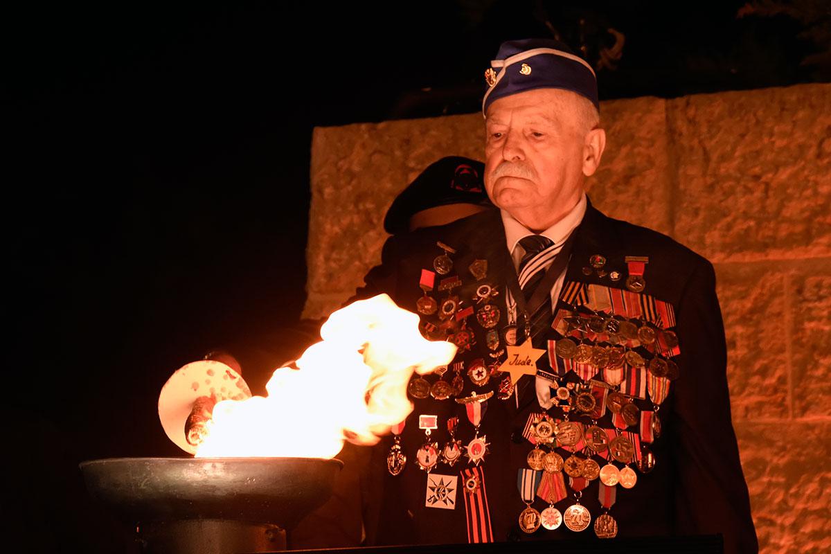 Holocaust survivor Max Privler lights one of the six torches at the ceremony