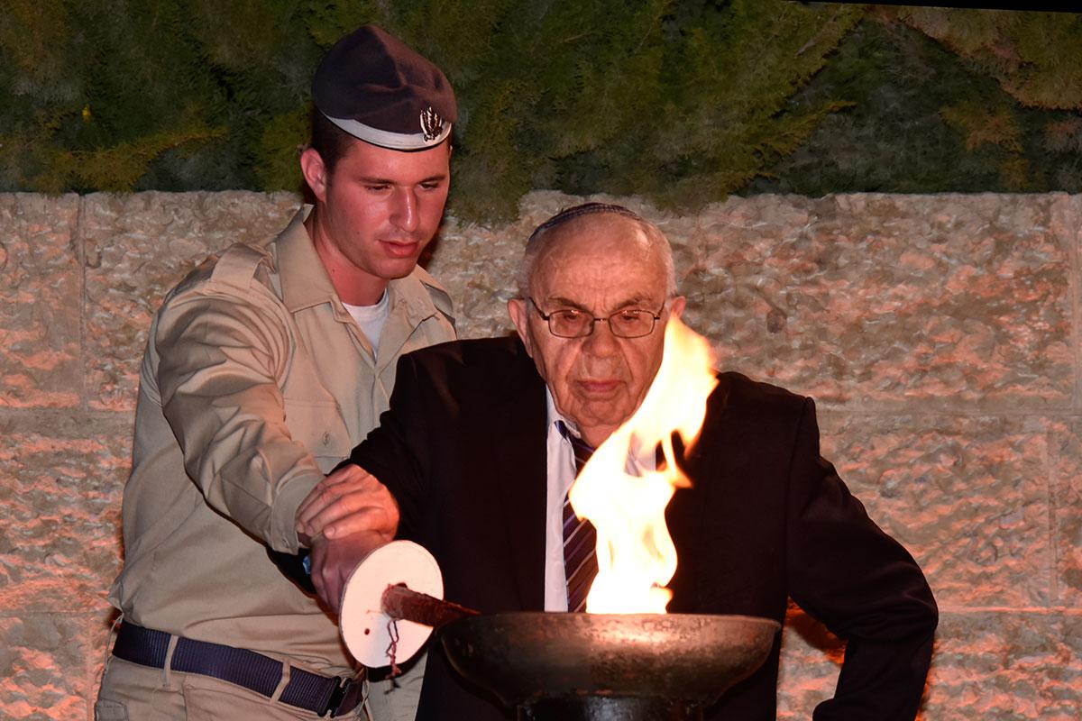 Holocaust survivor Menachem Haberman lights one of the six torches at the ceremony