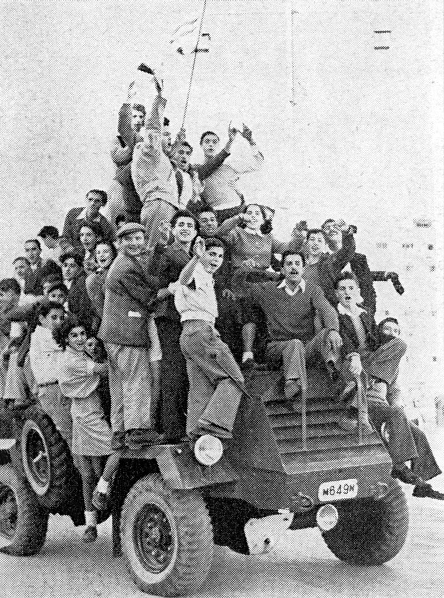 Las celebraciones durante la noche del 29 de noviembre de 1947 - Eleazar Shafrir enarbolando un bandera de Israel sobre un carro blindado británico