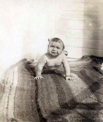 חנה התינוקת על שטיח שסרג אביה יעקב בשבי הגרמני מסיבי צמר שאסף מסוודרים שלבשו החיילים