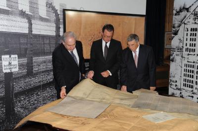 Prime Minister Benjamin Netanyahu, Bild Editor Kai Diekmann, and Chairman of the Yad Vashem Directorate Avner Shalev study the original plans of Auschwitz during the ceremony