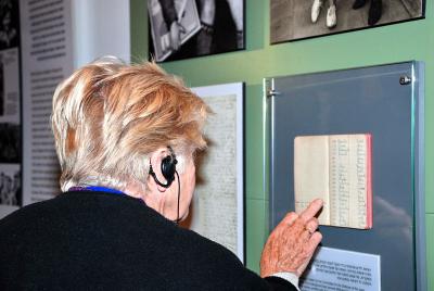 אנדרה גלן בביקורה במוזיאון יד ושם ליד תצוגת המחברות בהן רשמה את הילדים
