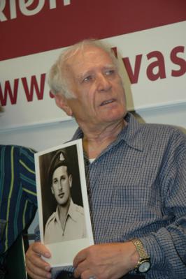 Simon Glasberg holding a photo of himself as a young man