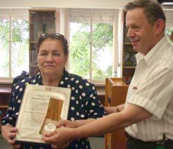 Pictured here is Yekaterina Panchenko Movchan receiving a medal and certificate from Dr. Mordecai Paldiel