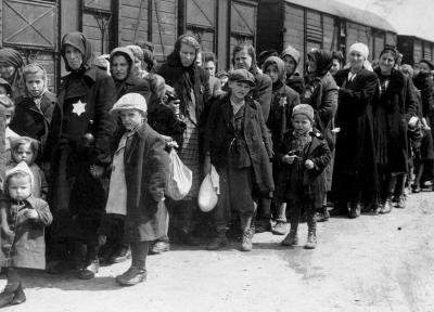 Frauen und Kinder auf dem Ankunftsbahnsteig in Birkenau, der als „Rampe“ bekannt ist. Die Juden wurden aus den Deportationszügen auf die Rampe geholt, wo sie einem Selektionsprozess unterzogen wurden – manche wurden sofort in den Tod geschickt, andere zur