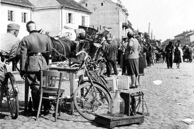 שוטרים גרמנים בודקים את רכושם של יהודים שגורשו. צולם על ידי צלם גרמני אנונימי בסוף 1942 או תחילת 1943.